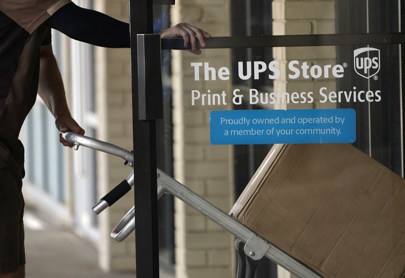 ARCHIVO - Un conductor de UPS entra en una tienda de United Parcel Service con paquetes en Jackson, Mississippi, el lunes 26 de julio de 2021. (AP foto/Rogelio V. Solis, archivo)