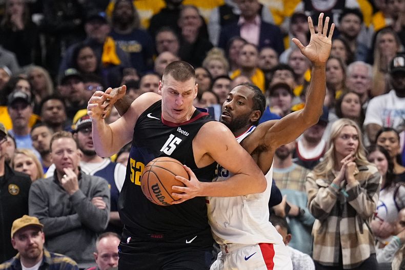 Nikola Jokic, pívot de los Nuggets de Denver, recibe una falta de Kawhi Leonard, de los Clippers de Los Ángeles, en el encuentro del martes 14 de noviembre de 2023 (AP Foto/Jack Dempsey)