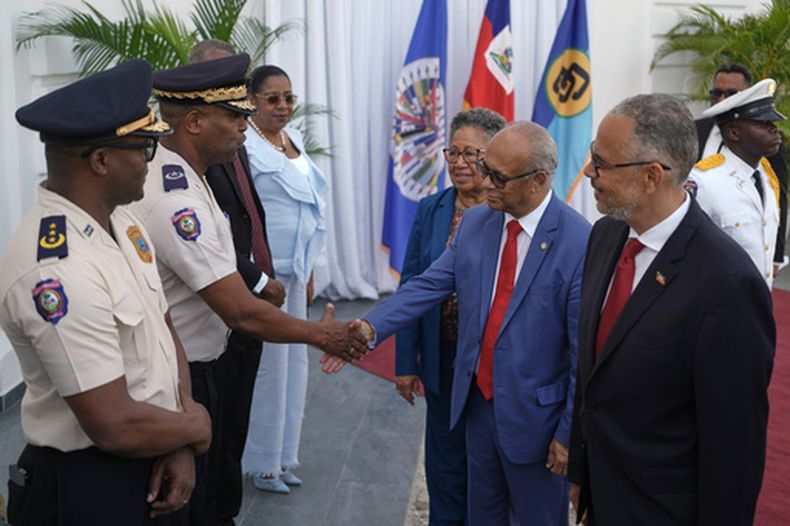 El primer ministro de Haití, Alix Didier Fils-Aimé, extremo derecho, el secretario general de la Organización de Estados Americanos (OEA) Albert Ramdin, segundo de derecha a izquierda, y la secretaria general de CARICOM, Carla Barnett, saludan a policías de alto rango en el Palacio Nacional de Puerto Príncipe, Haití, el lunes 17 de agosto de 2026. (AP Foto/Odelyn Joseph)
