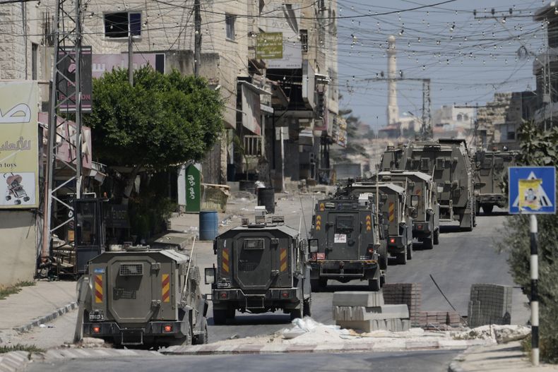 Una columna de vehículos blindados del ejército israelí abandona la localidad de Tubas, en Cisjordania, tras una operación militar, el 14 de agosto de 2024. (AP Foto/Majdi Mohammed)