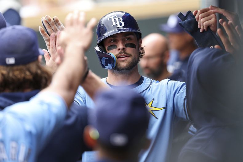 Josh Lowe de los Rays de Tampa Bay felicitado tras anotar con un dlbe de Randy Arozarena en el encuentro ante los Mellizos de Minnesota el jueves 20 de junio del 2024. (AP Foto/Matt Krohn)