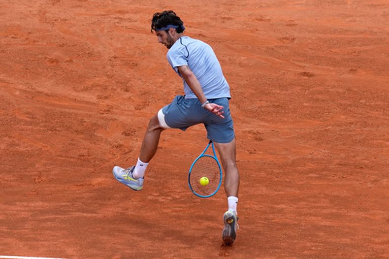 Lorenzo Musetti devuelve ante Casper Ruud en el Abierto de Italia, el martes 12 de myo de 2026, en Roma. (AP Foto/Alessandra Tarantino)
