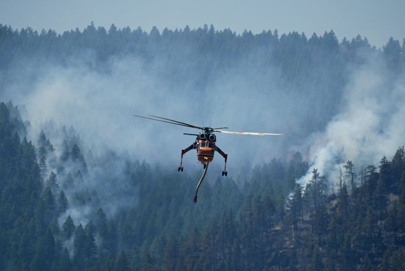 Un helicóptero se dirige a descargar agua sobre el incendio forestal Quarry que arde en las laderas cerca de Ken Caryl Ranch, el jueves, 1 de agosto 2024, al suroeste de Litteton, Colorado (Foto AP/ David Zalubowski).