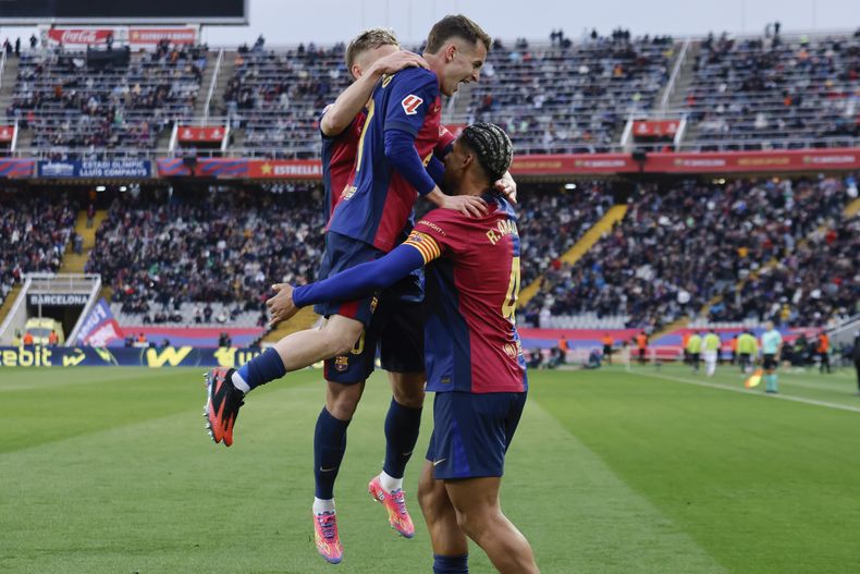 Ronald Araujo del Barcelona felicitado por sus compañeros tras anotar el tercer gol en el encuentro de la liga española ante la Real Sociedad el domingo dos de marzo del 2025. (AP Foto/Joan Monfort)