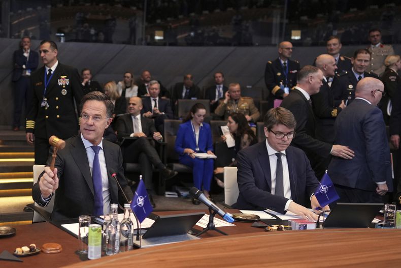 El secretario general de la OTAN, Mark Rutte (izquierda), anuncia el inicio de una cumbre de ministros de Defensa de la alianza golpeando un mazo, en la sede de la OTAN, en Bruselas, el 5 de junio de 2025. (AP Foto/Virginia Mayo)
