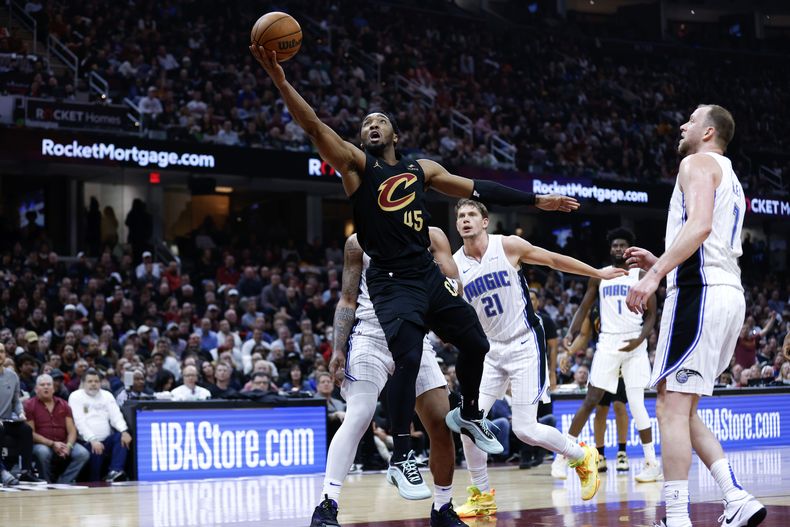 El base de los Cavaliers de Cleveland Donovan Mitchell lanza el balón ante el Magic de Orlando en el juego 5 de la primera ronda de la postemporada el martes 30 de abril del 2024. (AP Foto/Ron Schwane)