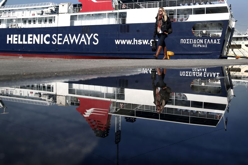 Una mujer camina cerca de un barco atracado en el puerto del Pireo, cerca de Atenas, durante una huelga general de 24 horas en Grecia, el mi&eacute;rcoles 9 de abril de 2014. Los sindicatos protestan contra las medidas de austeridad del gobierno. (AP Foto