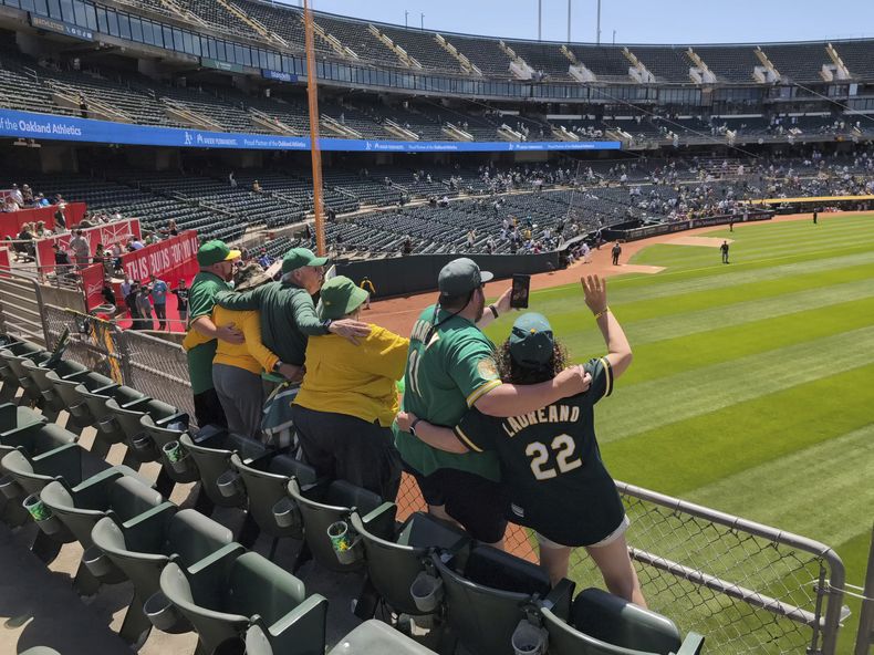 Will MacNeil y otros aficionados de los Atléticos cantan Take Me Out To The Ballgame en el Coliseo de Oakland durante el séptimo inning del juego contra los Piratas de Pittsburgh, el 1 de mayo de 2024, en Oakland, California. (AP Foto/Michael Liedtke)