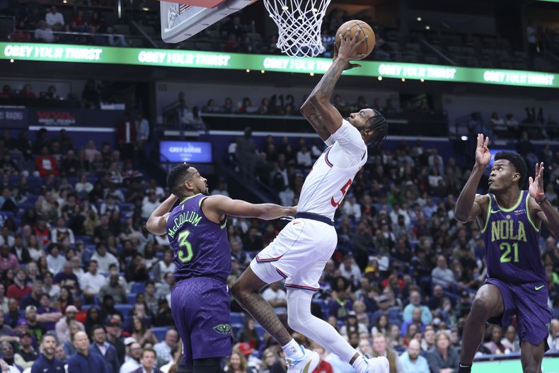 El alero de los Clippers de Los Ángeles Derrick Jones Jr. intenta lanzar un tiro de bandeja frente al base de los Pelicans de Nueva Orleans CJ McCollum en el encuentro del lunes 30 de diciembre del 2024. (AP Foto/Peter Forest)