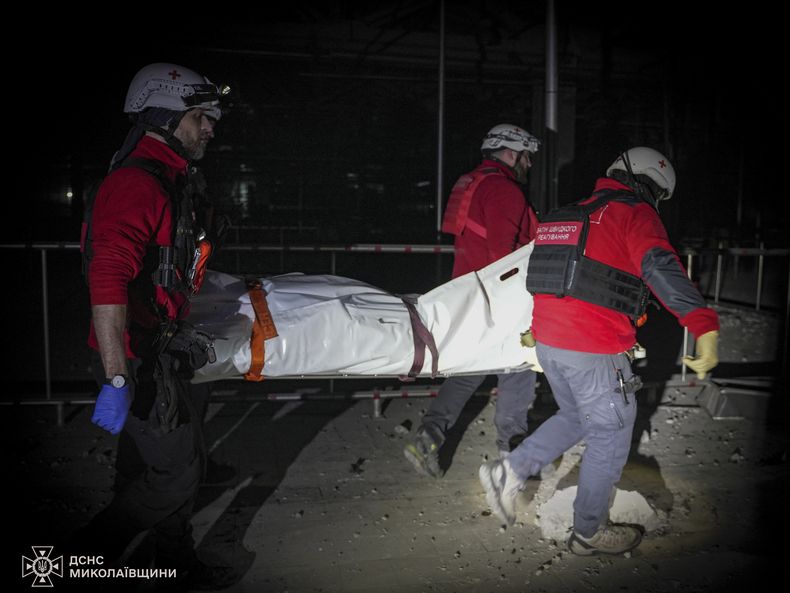 En esta imagen proporcionada por el Servicio Ucraniano de Emergencias rescatistas llevan el cuerpo de un civil que murió cuando un dron ruso golpeó una planta de comida en la ciudad de Mykolaiv, Ucrania, el miércoles 29 de enero de 2025. (Servicio Ucraniano de Emergencias via AP)