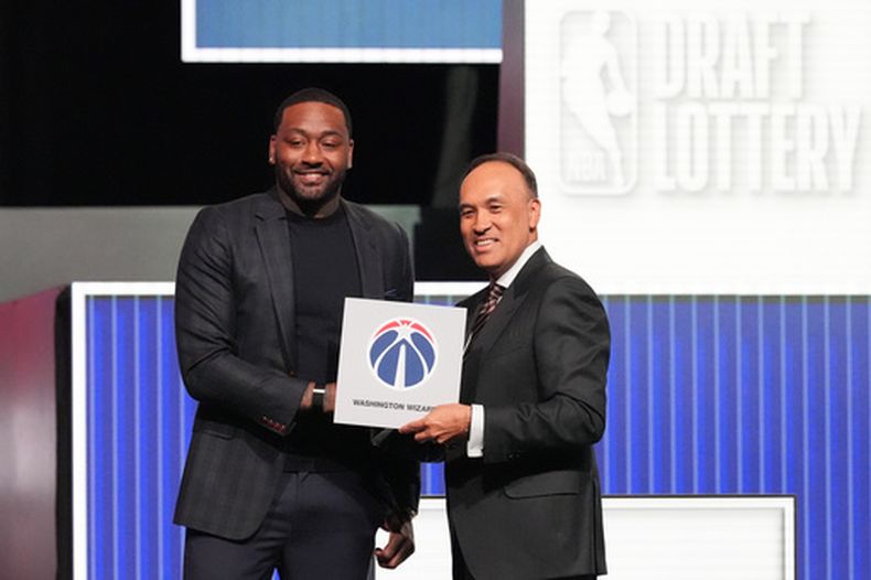 John Wall, de los Wizards de Washington (izquierda), y el comisionado adjunto de la NBA, Mark Tatum, posan para fotos después de que Tatum anunciara que los Wizards ganaron la primera selección en la lotería del draft de baloncesto de la NBA en Chicago, el domingo 10 de mayo de 2026. (Foto AP/Nam Y. Huh)