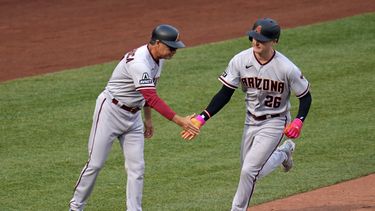 Pavin Smith, de los Diamondbacks de Arizona, recorre la antesala es felicitado por el coach Tony Perezchica, luego de batear un jonrón el sábado 20 de mayo de 2023, ante los Piratas de Pittsburgh (AP Foto/Gene J. Puskar)