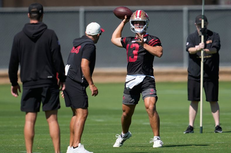Brock Purdy (13), quarterback de los 49ers de San Francisco, lanza un pase durante la práctica del equipo en el campamento de entrenamiento, el lunes 27 de julio de 2026, en Santa Clara, California. (AP Foto/Jeff Chiu)