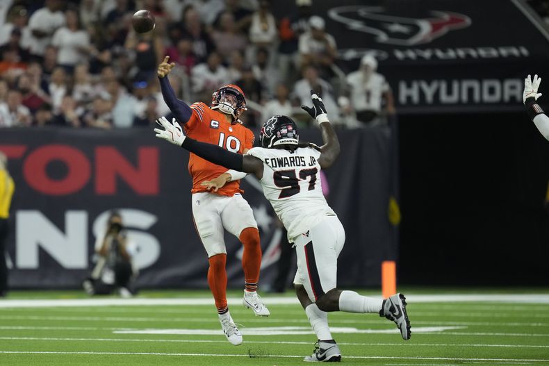 Caleb Williams (18), quarterback de los Bears de Chicago, lanza sobre el defensive tackle Mario Edwards Jr. (97), de los Texans de Houston, surante la segunda mitad del juego de la NFL, el domingo 15 de septiembre de 2024, en Houston. (AP Foto/Eric Christian Smith)