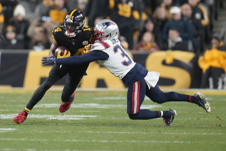 El receptor de los Steelers de Pittsburgh George Pickens es derribado por el cornerback de los Patriots de Nueva Inglaterra Jonathan Jones después de atrapar un pase en la segunda mitad del partido del jueves 7 de diciembre de 2023, en Pittsburgh. (AP Foto/Gene J. Puskar)