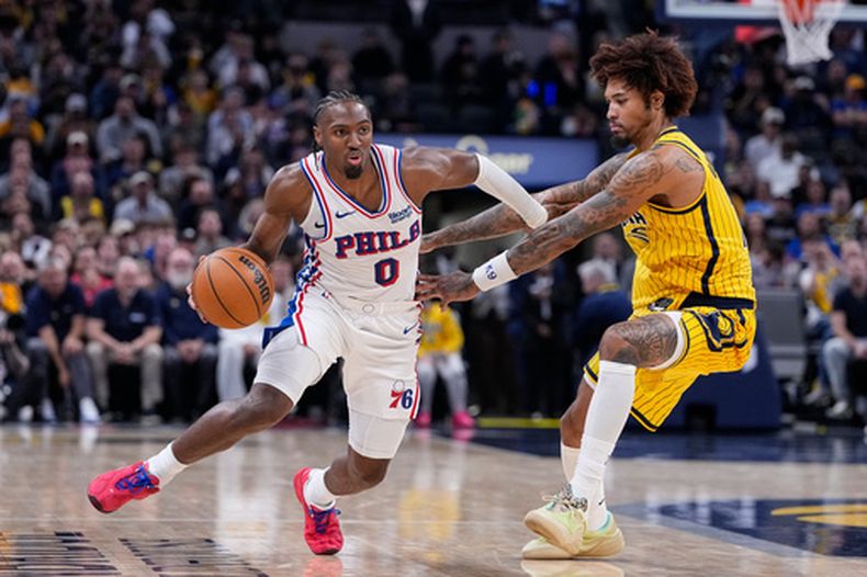 Tyrese Maxey (0), de los 76ers de Filadelfia, lleva el balón frente a Kelly Oubre Jr. (10), de los Pacers de Indiana, durante la segunda mitad del juego de baloncesto de la NBA, el miércoles 28 de 2026, en Indianápolis. (AP Foto/Michael Conroy)