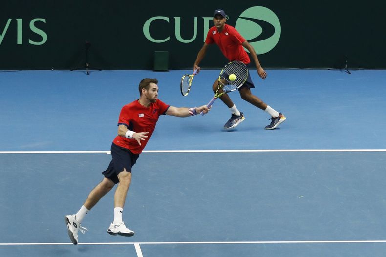 Austin Krajicek, de Estados Unidos, izquierda, devuelve una pelota al lado de su compañero Rajeev Ram durante el partido de dobles contra Illya Beloborodko y Oleksii Krutykh, de Ucrania, durante la serie clasificatoria entre Ucrania y Estados Unidos, en Vilnius, Lituania, el viernes 2 de febrero de 2024. (AP Foto/Mindaugas Kulbis)