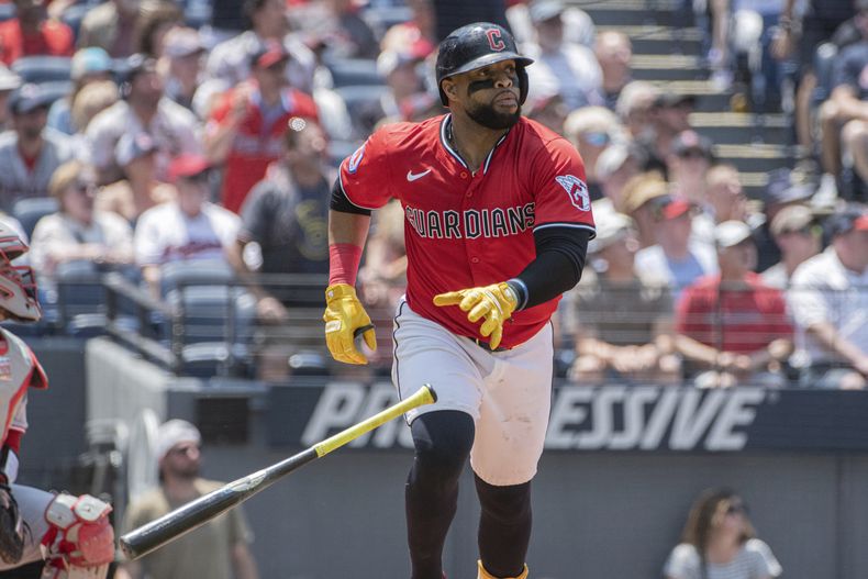 Carlos Santana de los Guardianes de Cleveland observa la pelota tras batear un jonrón ante los Rojos de Cincinnati, el miércoles 11 de junio de 2025, en Cleveland. (AP Foto/Phil Long)
