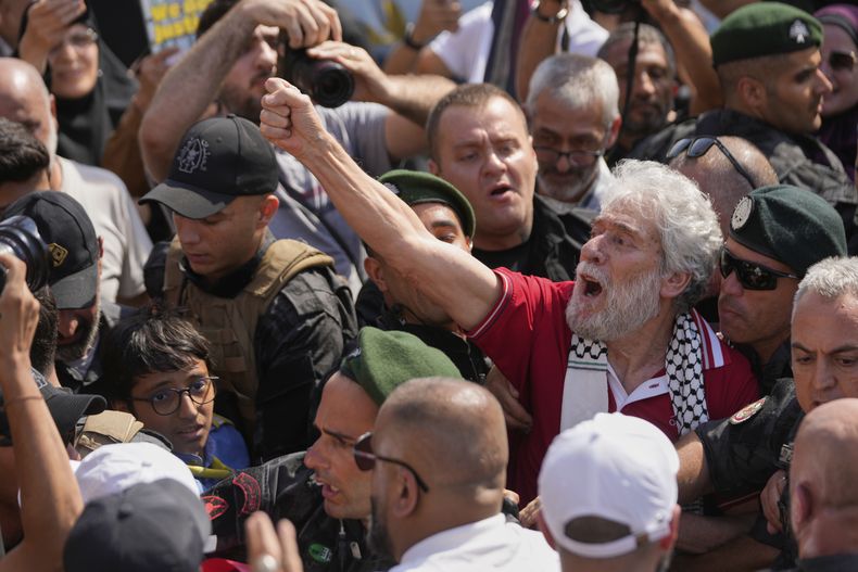 El militante libanés propalestino Georges Abdallah, segundo de derecha a izquierda, quien cumplía cadena perpetua por complicidad en los asesinatos de un diplomático estadounidense y uno israelí en París en 1982, levanta el puño y corea entre sus partidarios a su llegada al Aeropuerto Internacional Rafik Hariri de Beirut, Líbano, el viernes 25 de julio de 2025. (AP Foto/Hussein Malla)