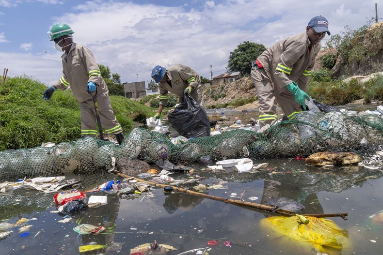 ARCHIVO - Voluntarios de la organización ambiental Alexandra Water Warriors realizan tareas de limpieza en el río Juksei, en el corazón del municipio de Alexandra, en las afueras de Johannesburgo, Sudáfrica, el 27 de noviembre de 2024. (AP Foto/Jerome Delay, archivo)