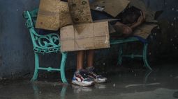 Personas en una parada de autobús se protegen con cartones del viento y la lluvia durante el paso del huracán Rafael en La Habana, Cuba, el miércoles 6 de noviembre de 2024. Tras su paso, la isla buscaba recuperarse; un apagón nacional provocado por el huracán se mantiene en gran parte del país el 7 de noviembre de 2024. (Foto AP/Ramón Espinosa)
