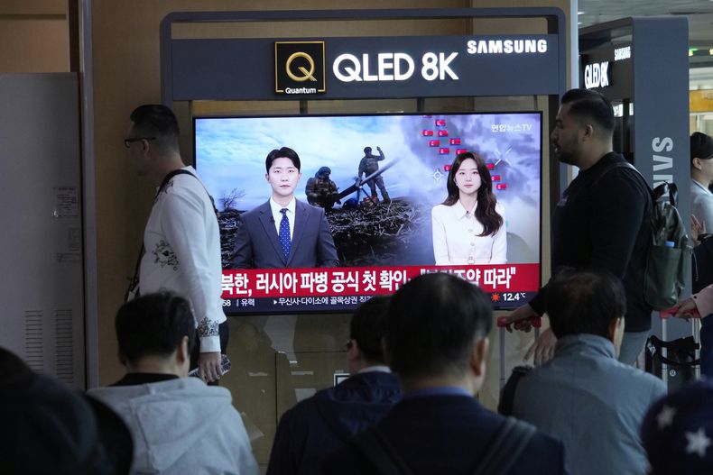 Dos personas pasan por delante de un televisor durante la emisión de un noticiero en el que se confirma el envío de soldados norcoreanos a Rusia, en la estación de tren de Seúl, Corea del Sur, el 28 de abril de 2025. (AP Foto/Ahn Young-joon)