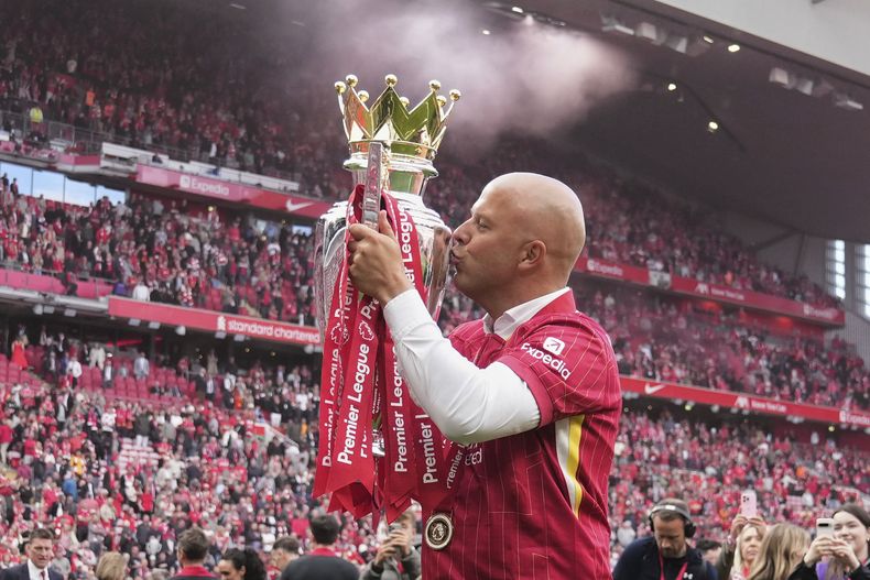 El técnico Arne Slot besa el trofeo de la Liga Premier durante la celebración al final del partido contra Crystal Palace, el domingo 25 de mayo de 2025, en el estadio Anfield. (AP Foto/Jon Super)
