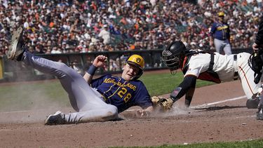 Joey Wiemer (28), de los Cerveceros de Milwaukee, anota ante el intento de toque del receptor de los Gigantes de San Francisco, Blake Sabol, durante la novena entrada del juego de béisbol en San Francisco, el domingo 7 de mayo de 2023. (AP Foto/Jeff Chiu)