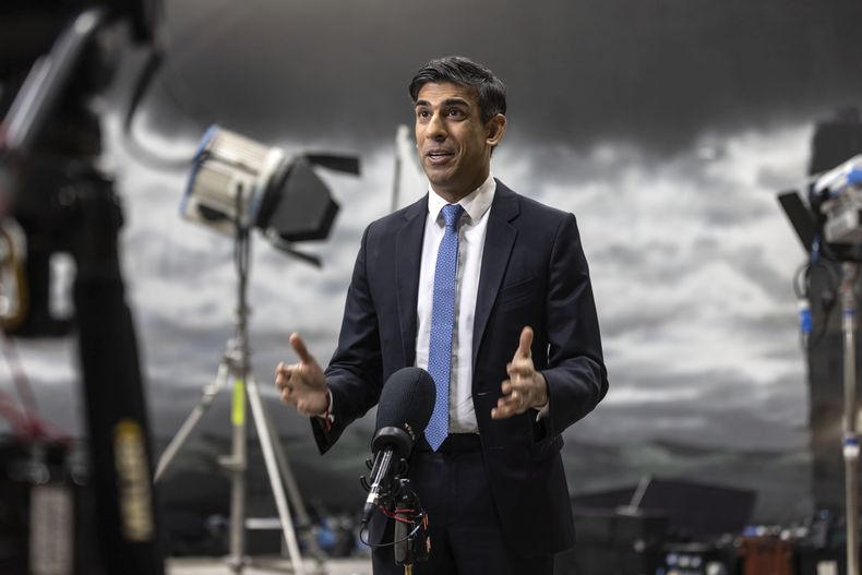 El primer ministro británico, Rishi Sunak, habla durante una entrevista en televisión ante un mural pintado de un cielo tormentoso creado por estudiantes en un estudio de cine de la Facultad Nacional de Cine y Televisión, en Beaconsfield, Inglaterra, el lunes 22 de enero de 2024. (Richard Pohle, Pool Foto via AP)