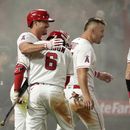 Zach Neto (izquierda), de los Angelinos de Los Ángeles, festeja luego de anotar la carrera del triunfo sobre los Rangers de Texas, el viernes 5 de mayo de 2023 (AP Foto/Mark J. Terrill)