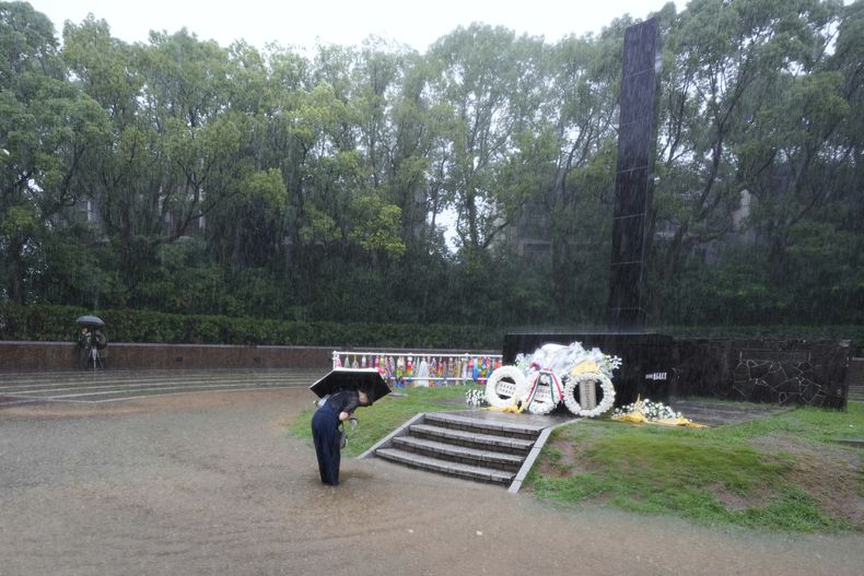 Una persona se inclina para rezar bajo la lluvia, en el Parque de la Paz antes de una ceremonia pública para conmemorar el 80 aniversario del día en que se arrojó una bomba nuclear sobre la ciudad, en Nagasaki, Japón, el 9 de agosto de 2025.(AP Foto/Eugene Hoshiko)