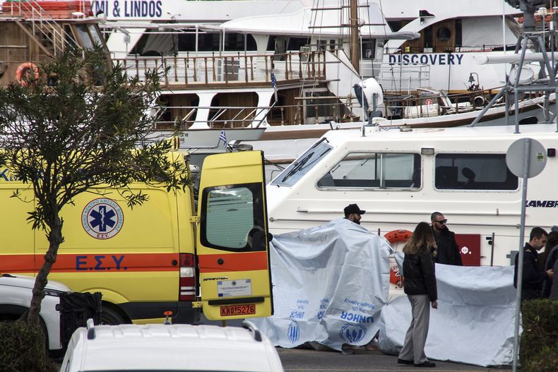 Agentes de la Guardia Costera cubren los cuerpos de las víctimas del naufragio de una lancha rápida, en la isla de Rodes, Grecia, el 20 de diciembre de 2024. (Argyris Mantikos/Eurokinissi vía AP)