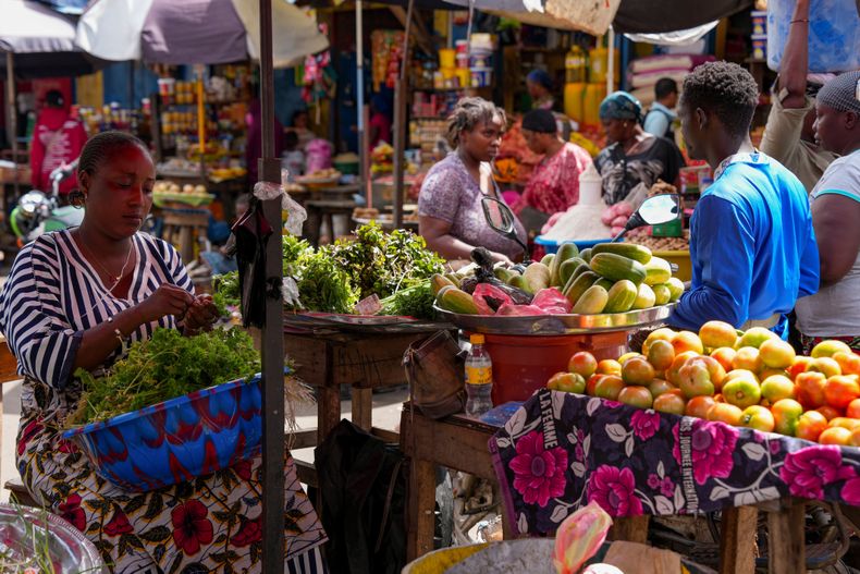 ARCHIVO - Una vendedora de verduras las organiza en un mercado el 19 de septiembre de 2025, en Conakry, Guinea. (AP Foto/Misper Apawu, Archivo)