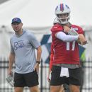 Joe Brady, izquierda, head coach de los Bills de Buffalo, observa al quarterback Josh Allen (17) mientras lanza el balón durante la práctica del equipo en el campamento de entrenamiento, el miércoles 29 de julio de 2026, en Pittsford, Nueva York. (AP Foto/Adrian Kraus)