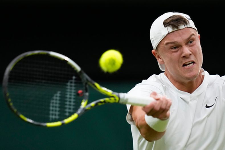 El danés Holger Rune regresa un tiro del serbio Novak Djokovic en la cuarta ronda de Wimbledon el lunes 8 de julio del 2024. (AP Foto/Kirsty Wigglesworth)