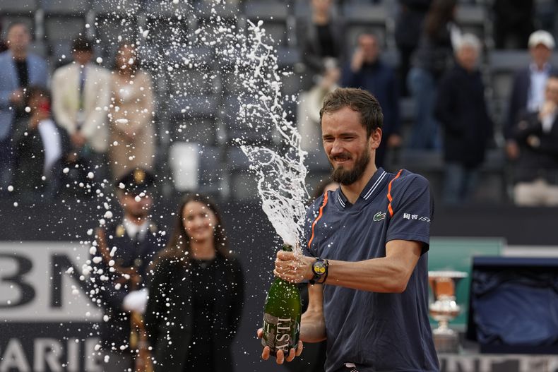 Daniil Medvedev suelta un vino espumante al festejar la victoria ante Holger Rune en la final del Abierto de Italia, el sábado 21 de mayo de 2023, en Roma. (AP Foto/Alessandra Tarantino)