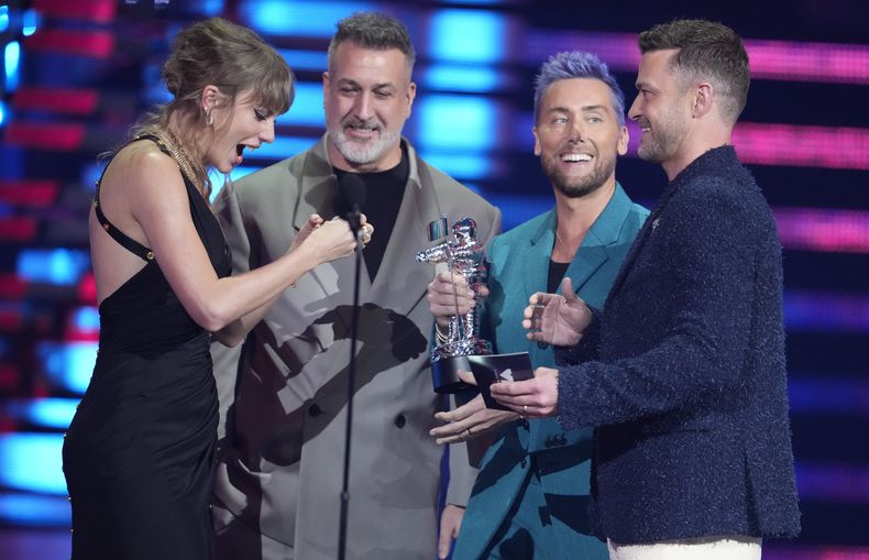 Joey Fatone, centro, Lance Bass, segundo de derecha a izquierda y Justin Timberlake, derecha, de NSYNC entregan el premio de mejor video pop a Taylor Swift por Anti-Hero en los Premios MTV a los Videos Musicales el martes 12 de septiembre de 2023 en el Prudential Center en Newark, Nueva Jersey. (Foto Charles Sykes/Invision/AP)