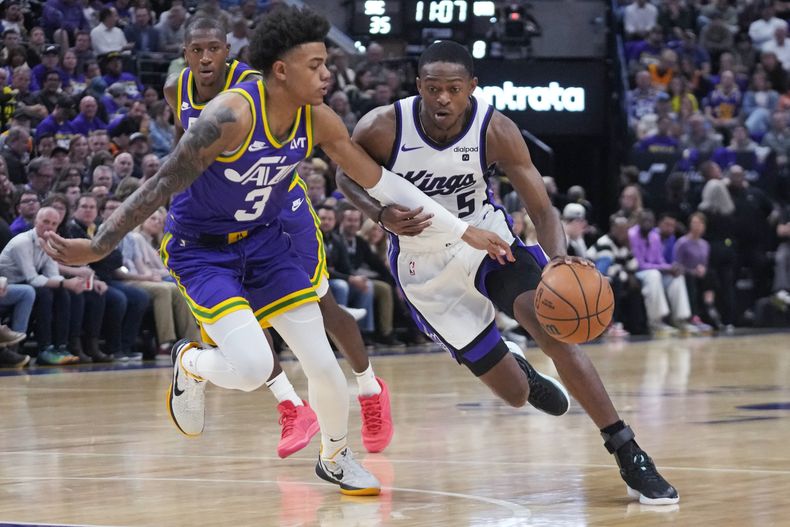 DeAaron Fox, base de los Kings de Sacramento, elude a Keyonte George, del Jazz de Utah, en el encuentro del miércoles 25 de octubre de 2023 (AP Foto/Rick Bowmer)
