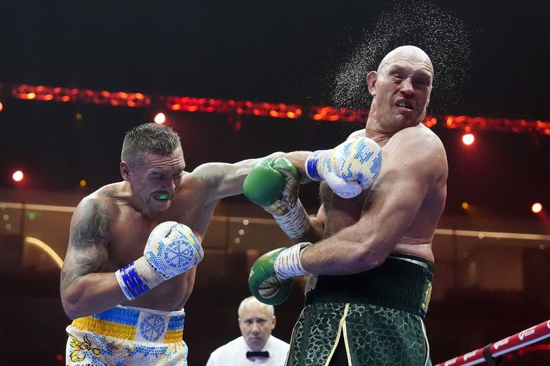 El ucraniano Oleksandr Usyk propina un golpe al británico Tyson Fury, durante su pelea por la unificación del título de los pesados, la madrugada del domingo 19 de mayo de 2024, en Riad (Nick Potts/PA via AP)