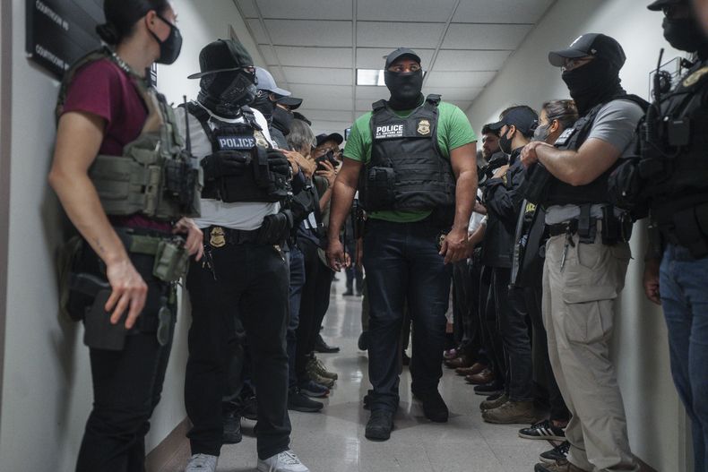 ARCHIVO – Agentes federales con el rostro oculto esperan fuera de una sala del tribunal de migración, el 8 de julio de 2025, en Nueva York. (AP Foto/Olga Fedorova, Archivo)