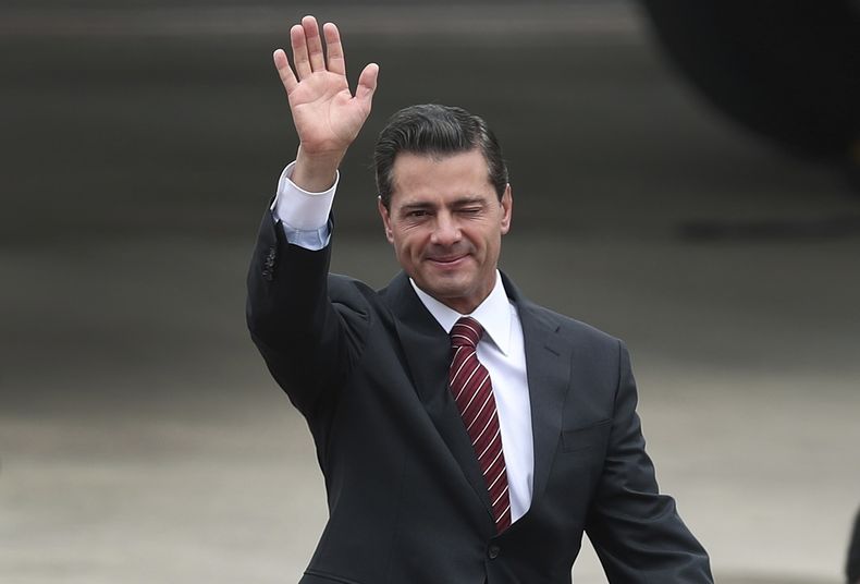 ARCHIVO - El presidente de México, Enrique Peña Nieto, saluda tras llegar al aeropuerto internacional Ministro Pistarini para asistir a la Cumbre del G20 en Buenos Aires, Argentina, el 29 de noviembre de 2018. (Foto AP/Martín Mejía, Archivo)