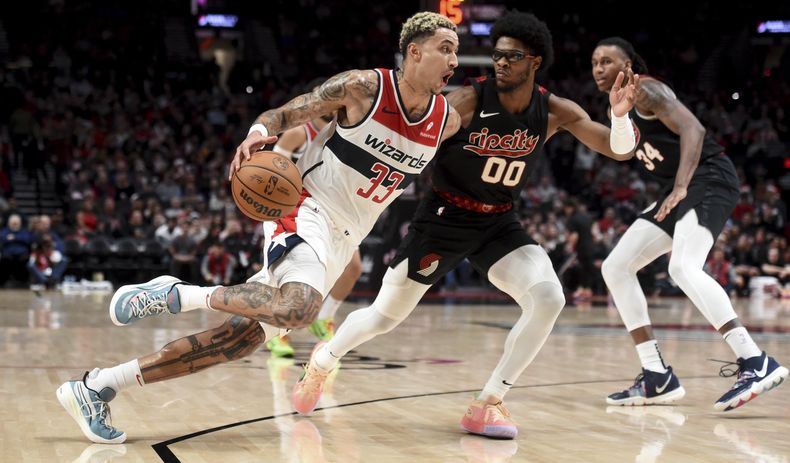 Kyle Kuzma, alero de los Wizards de Washington, avanza a la canasta frente a Scoot Henderson, de los Trail Blazers de Portland, el jueves 21 de diciembre de 2023 (AP Foto/Steve Dykes)