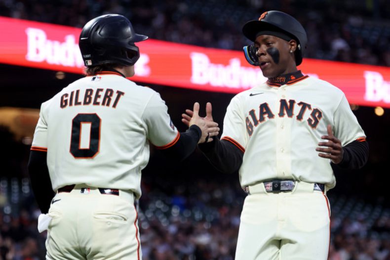 Bo Davidson, derecha, de los Gigantes de San Francisco, celebra con Drew Gilbert (0) después de anotar con un sencillo de Brett Harris durante la primera entrada del juego de béisbol de Grandes Ligas contra los Mellizos de Minnesota, el lunes 21 de septiembre de 2026, en San Francisco. (AP Foto/Jed Jacobsohn)
