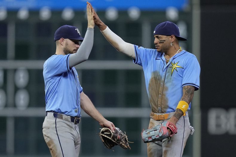 El segunda base de los Rays de Tampa Bay, Brandon Lowe, a la izquierda, y el jardinero central José Siri, a la derecha, celebran después de un juego contra los Astros de Houston, el sábado 3 de agosto de 2024, en Houston. (AP Foto/Kevin M. Cox)