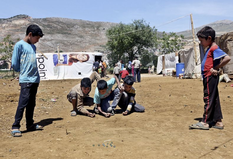 Unos ni&ntilde;os juegan a las canicas en un campo de refugiados para sirios en Kab Elias, L&iacute;bano, el 29 de abril de 2014. (Foto AP/Bilal Hussein)