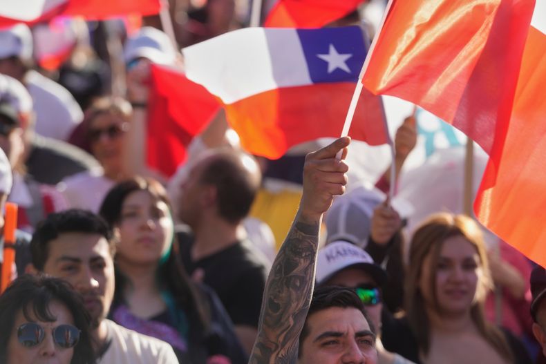 Simpatizantes del candidato presidencial Johannes Kaiser, del Partido Libertario Nacional, ondean banderas durante un mitin previo a las próximas elecciones generales, en Santiago de Chile, el miércoles 12 de noviembre de 2025. (Foto AP/Esteban Félix)