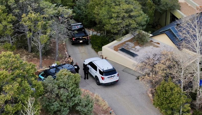 ARCHIVO - Autoridades hablan frente a la casa del actor Gene Hackman el jueves 27 de febrero de 2025 en Santa Fe, Nuevo México. Hackman, su esposa Betsy Arakawa y uno de sus perros fueron encontrados muertos en la vivienda un día antes. (Foto AP/Roberto Rosales, archivo)