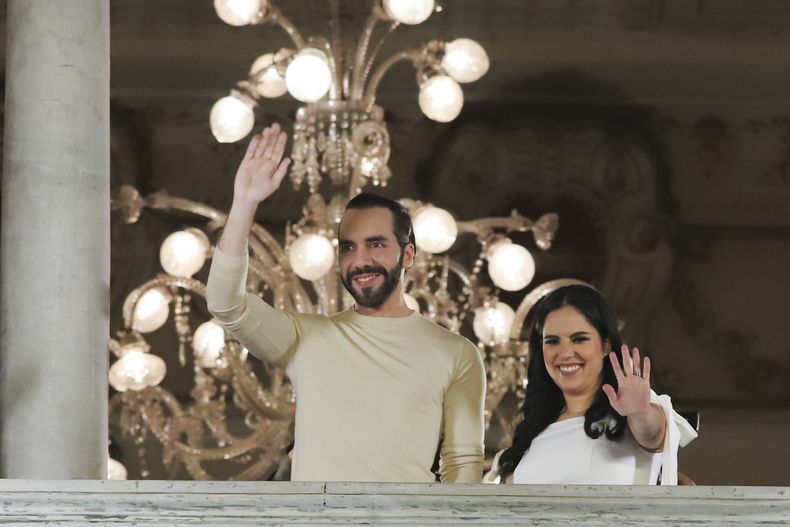 El presidente de El Salvador, Nayib Bukele, a la izquierda, acompañado de su esposa Gabriela Rodríguez, saludan a sus simpatizantes desde el balcón del palacio presidencial en San Salvador, El Salvador, tras el cierre de urnas en las elecciones generales del domingo 4 de febrero de 2024. Bukele y su partido Nuevas Ideas ganaron con amplia ventaja las elecciones, lo que garantiza al oficialismo el control del Congreso, según los resultados oficiales anunciados el lunes 19 de febrero. (AP Foto/Salvador Meléndez, Archivo)