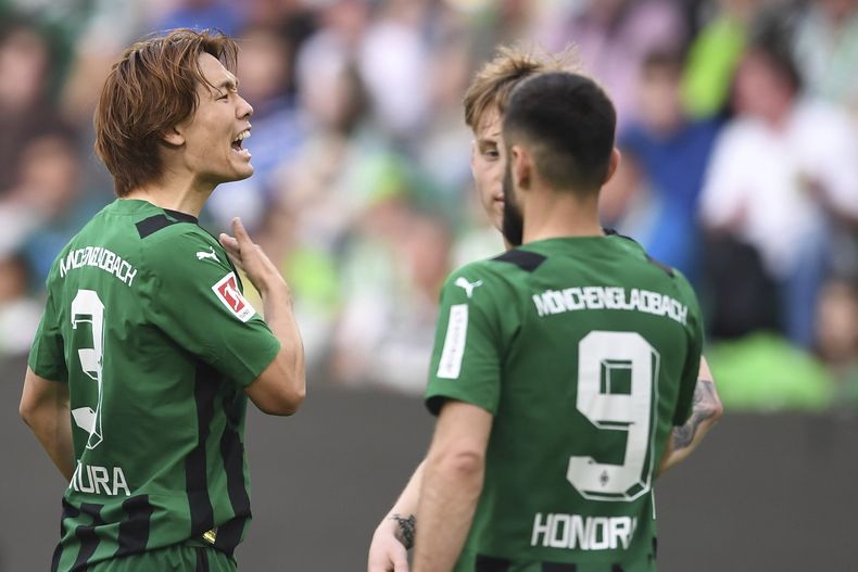 Ko Itakura (izquierda) celebra tras anotar el primer gol de Borussia Monchengladbach ante Wolfsburg en la Bundesliga, el domingo 7 de abril de 2024. (Swen Pförtner/dpa vía AP)