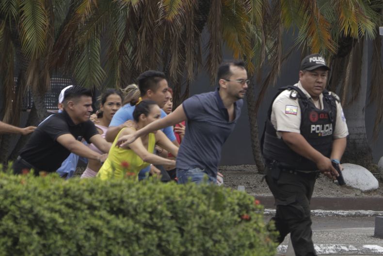 La policía evacúa a personal del canal TC Televisión después de que un grupo armado y encapuchado irrumpiera en plena transmisión en directo, en Guayaquil, Ecuador, el martes 9 de enero de 2024. El país ha registrado una secuencia de ataques violentos desde que el gobierno decretara el estado de excepción el lunes 8 de enero, tras la presunta fuga de un peligroso cabecilla de una banda criminal que opera en el país. (AP Foto/César Muñoz)